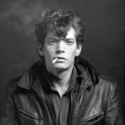 Self-Portrait in leather jacket, smoking cigarette.
