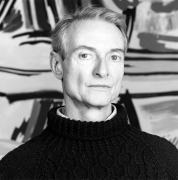 Portrait of Roy Lichtenstein in front of painting.