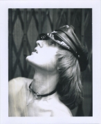 Nude white male in profile from the chest up, wearing leather hat and choker.