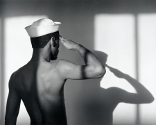 Shirtless man photographed from behind wearing a sailor hat
