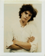 Self-Portrait polaroid of the artist with arms folded.