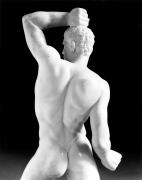 Statue of male body from behind.