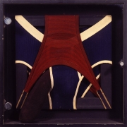 A red pair and a blue pair of mens underwear stretched around a black frame. A stuffed sock peeks out of the front of the blue pair of underwear.