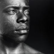 A bronze bust of a young black man looking past the picture plane.