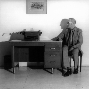 Portrait of William Burroughs at a desk.