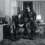 Portrait of two men in full leather outfits, facing camera head on.