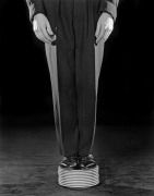 Person in suit standing on stack of plates.