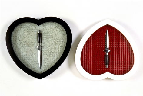 A pair of heart-shaped frames next to each other, each with a knife inside and glazed wire mesh. The white frame is upside down and red inside.