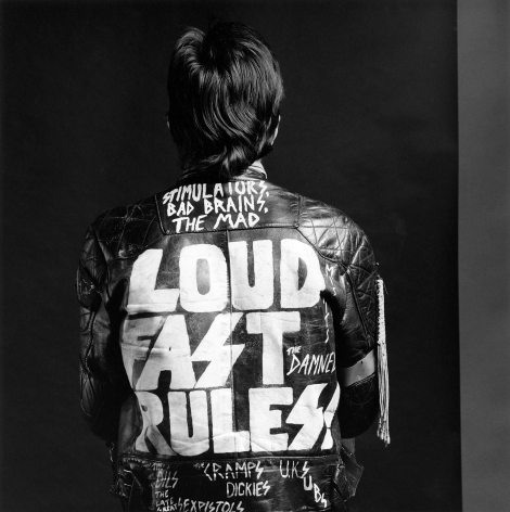 Nick Marden facing away from camera wearing leather jacket with text "Loud, Fast, Rules".