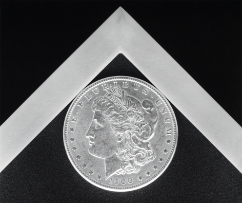 Coin nestled into the corner of a white graphic angle against a black background.