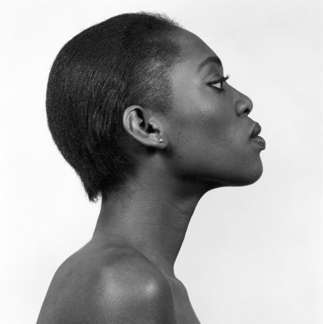 Profile view of a Black woman, hair slicked back, chin tilted up.