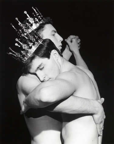 Two shirtless white men dancing, wearing crowns.