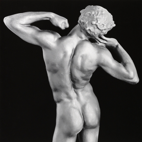 Nude sculpture facing away from camera in a pose.